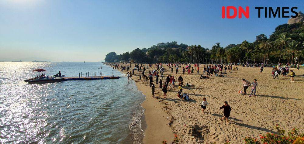ilustrasi Wisatawan bersantai dan bermain air di pinggir pantai (IDN Times/Mela Hapsari)
