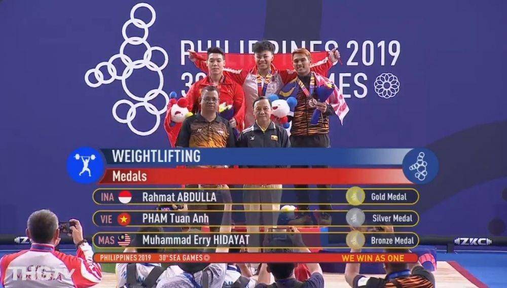 Rahmat Abdullah meraih emas ketiga cabor angkat besi di SEA Games 2019. Twitter/@BadmintonTalk