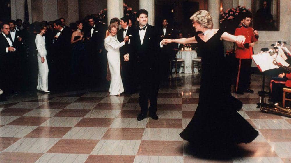 Putri Diana berdansa dengan John Travolta mengenakan gaun velvet biru yang dirancang oleh Victor Edelstein saat menghadiri State Dinner di White House pada 9 November 1985. (Yahoo News/Corbis, Pool)