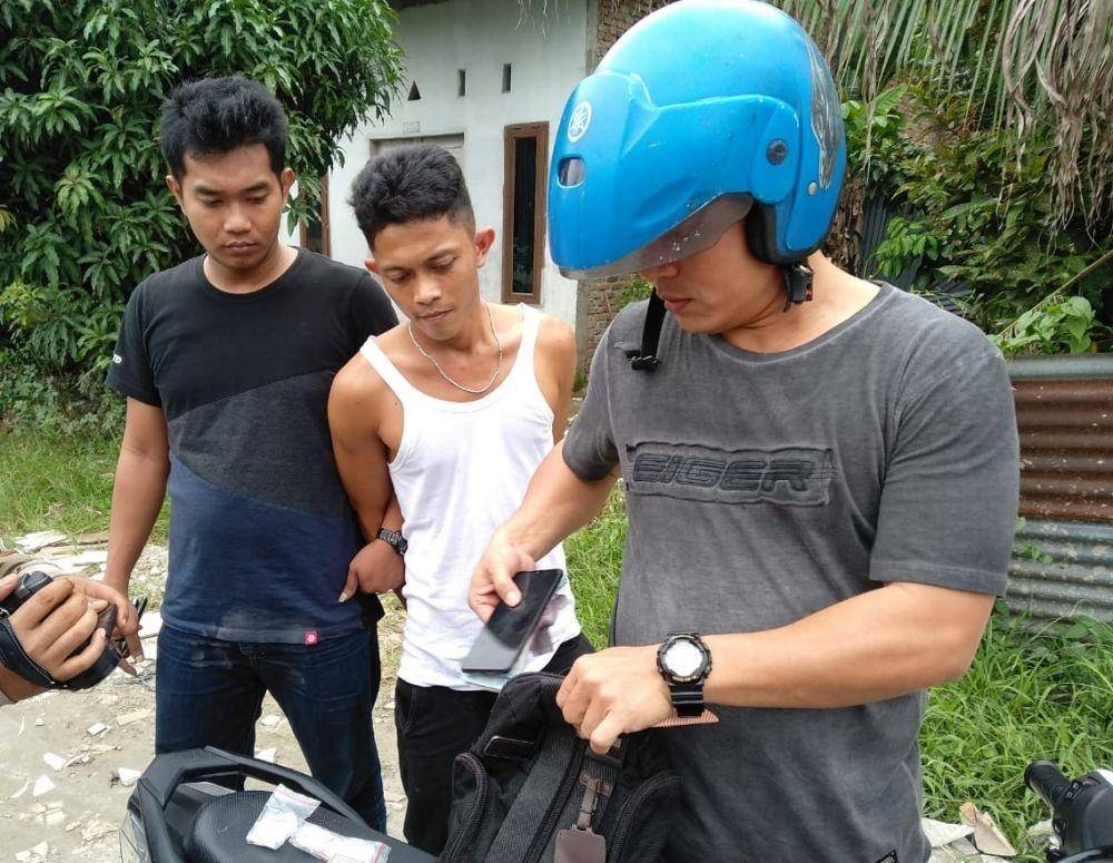 Personel Satres Narkoba Polrestabes Medan saat mengamankan terduga pelaku (pakai singlet) di lokasi penggerebekan