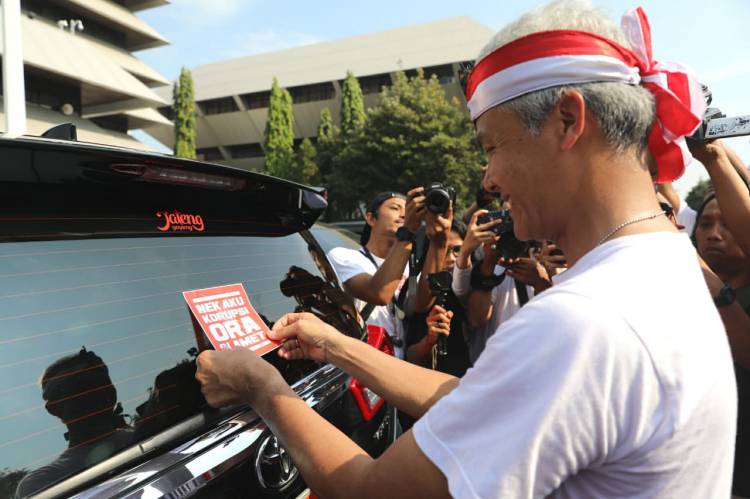 Gubernur Jateng Ganjar Pranowo menempel stiker antikorupsi ke mobil dinas pejabat Pemprov Jateng, Minggu (8/12). Humas Jateng/Slam