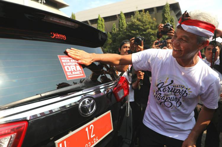 Gubernur Jateng Ganjar Pranowo menempel stiker antikorupsi ke mobil dinas pejabat Pemprov Jateng, Minggu (8/12). Humas Jateng/Slam