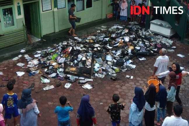 Sejumlah siswa MI Batujajar bersama warga gotong royong membersihkan puing sisa kebakaran yang melanda sekolah tersebut. (IDN Times/Bagus F)
