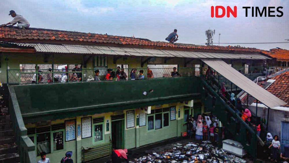 Sejumlah siswa MI Batujajar bersama warga gotong royong membersihkan puing sisa kebakaran yang melanda sekolah tersebut. (IDN Times/Bagus F)