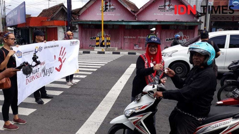 Pegawai KPP Wates bagikan souvenir kepada pengguna jalan. IDN Times/Daruwaskita