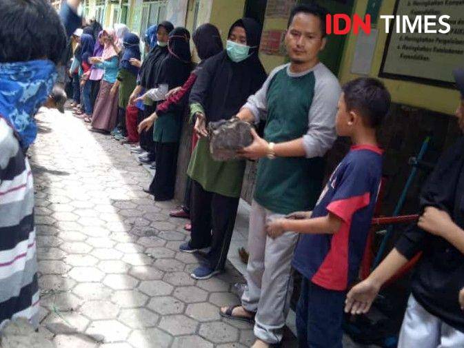 Sejumlah siswa MI Batujajar bersama warga gotong royong membersihkan puing sisa kebakaran yang melanda sekolah tersebut. (IDN Times/Bagus F)