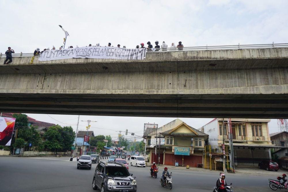 Aktivis saat membentangkan spanduk di jalan layang Samarinda (Dok. Aksi Kamisan Kaltim)