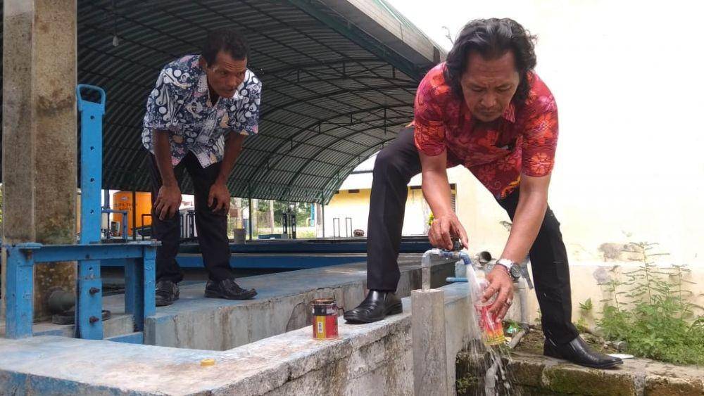 Salah satu anggota DPRD Kabupaten Lamongan menunjukkan air PDAM yang tercemar limbah tekstil. IDN Times/Imron