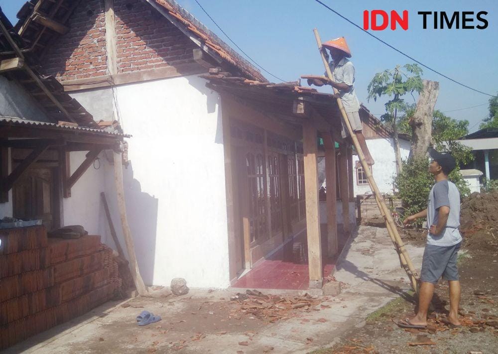 Warga membenahi atap rumahnya yang tersapu angin kencang di Kabupaten Madiun. IDN Times/Nofika Dian Nugroho