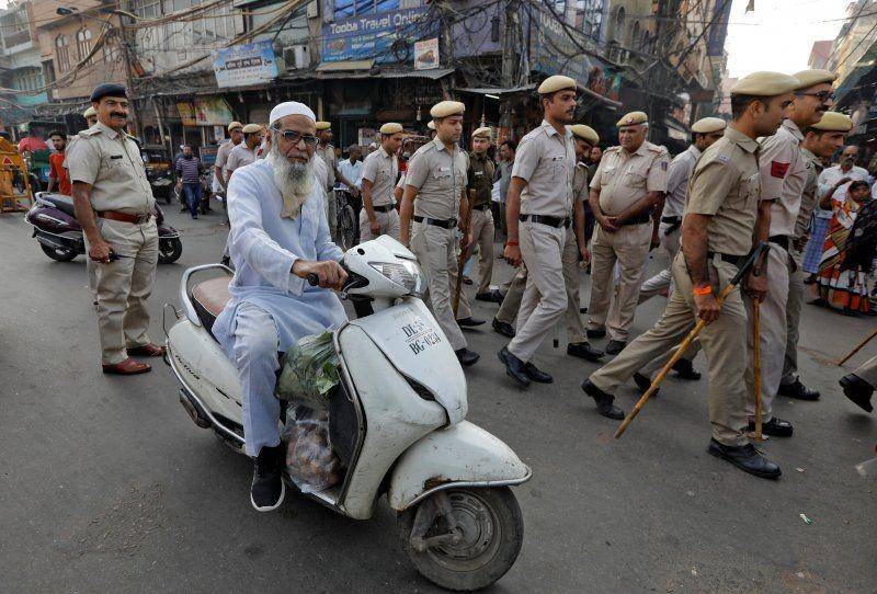 Seorang pria Muslim mengendarai skuter saat polisi melakukan pawai bendera di luar Mesjid Jama, sebelum putusan Mahkamah Agung tentang sengketa tempat relijius yang diklaim oleh umat Hindu dan Muslim di Ayodhya, di kota tua Delhi, India, pada 9 November 2019. (ANTARA FOTO/REUTERS/Adnan Abidi)