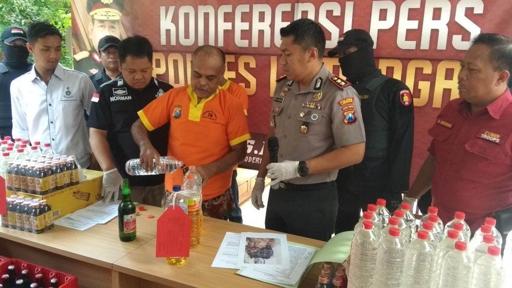 Tersangka kasus penjualan miras oplosan memperagakan cara meracik miras. IDN Times/Imron