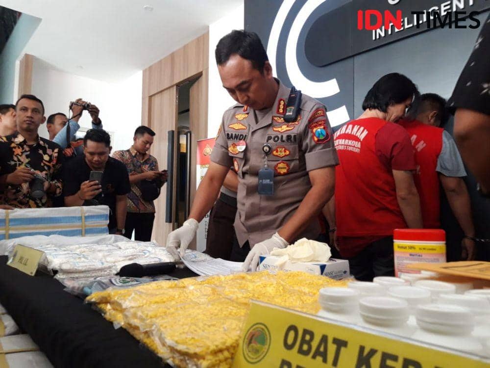 Kapolrestabes Surabaya Kombes Pol Sandi Nugroho mengamati barang bukti pil koplo dan dextro yang disita anak buahnya. IDN Times/Fitria Madia