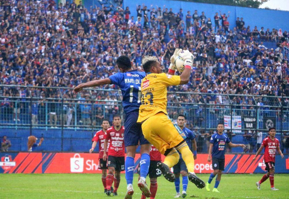 Striker Arema FC, Rivaldi Bawuo berduel dengan kiper Bali United, Samuel Reimas di Stadion Kanjuruhan, Senin (16/12/2019). IDN Times/ Alfi Ramadana