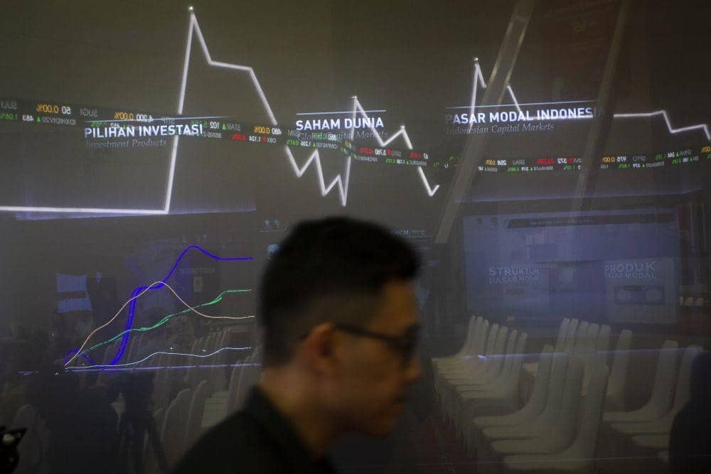 Pengunjungi berjalan di samping layar pergerakan saham di Bursa Efek Indonesia (BEI), Jakarta. ANTARA FOTO/Dhemas Reviyanto