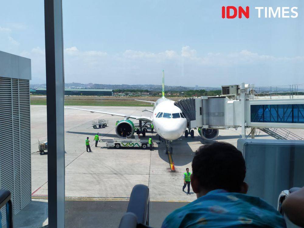 Seorang anak sedang menonton pesawat Citilink yang parkir di Bandara Ahmad Yani. IDN Times/Fariz Fardianto
