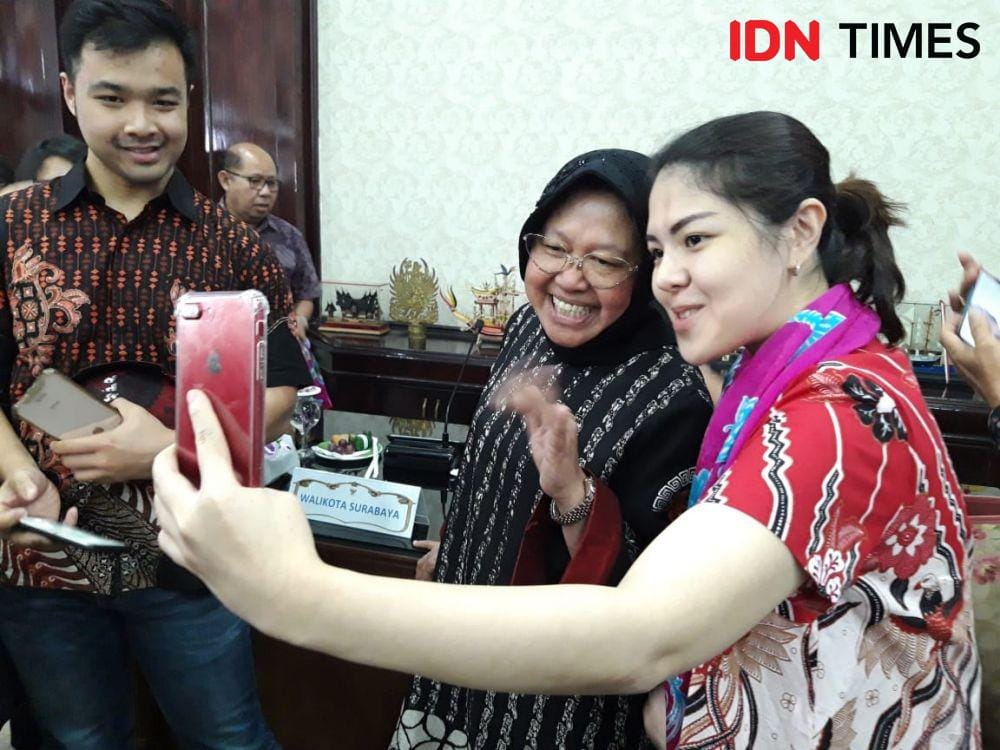 Agustina Hermanto atau Tina Toon (kanan) mengajak Wali Kota Surabaya Tri Rismaharini berswafoto saat kunjungan di Ruang Sidang Wali Kota Surabaya, Jumat (20/12). IDN Times/Fitria Madia