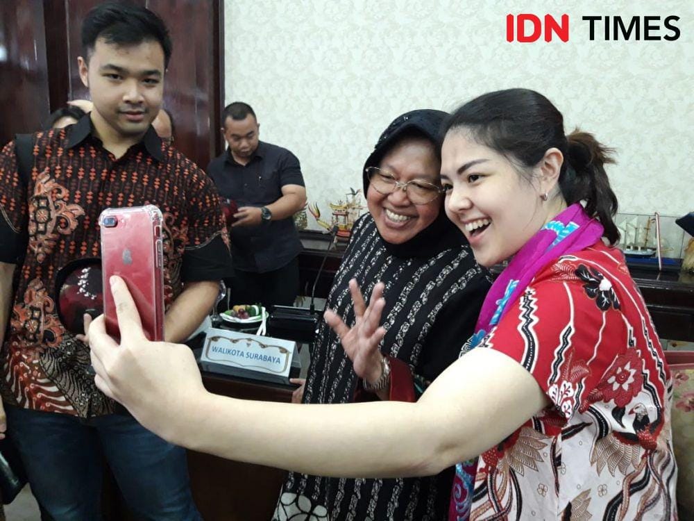 Agustina Hermanto atau Tina Toon (kanan) mengajak Wali Kota Surabaya Tri Rismaharini berswafoto saat kunjungan di Ruang Sidang Wali Kota Surabaya, Jumat (20/12).  IDN Times/Fitria Madia