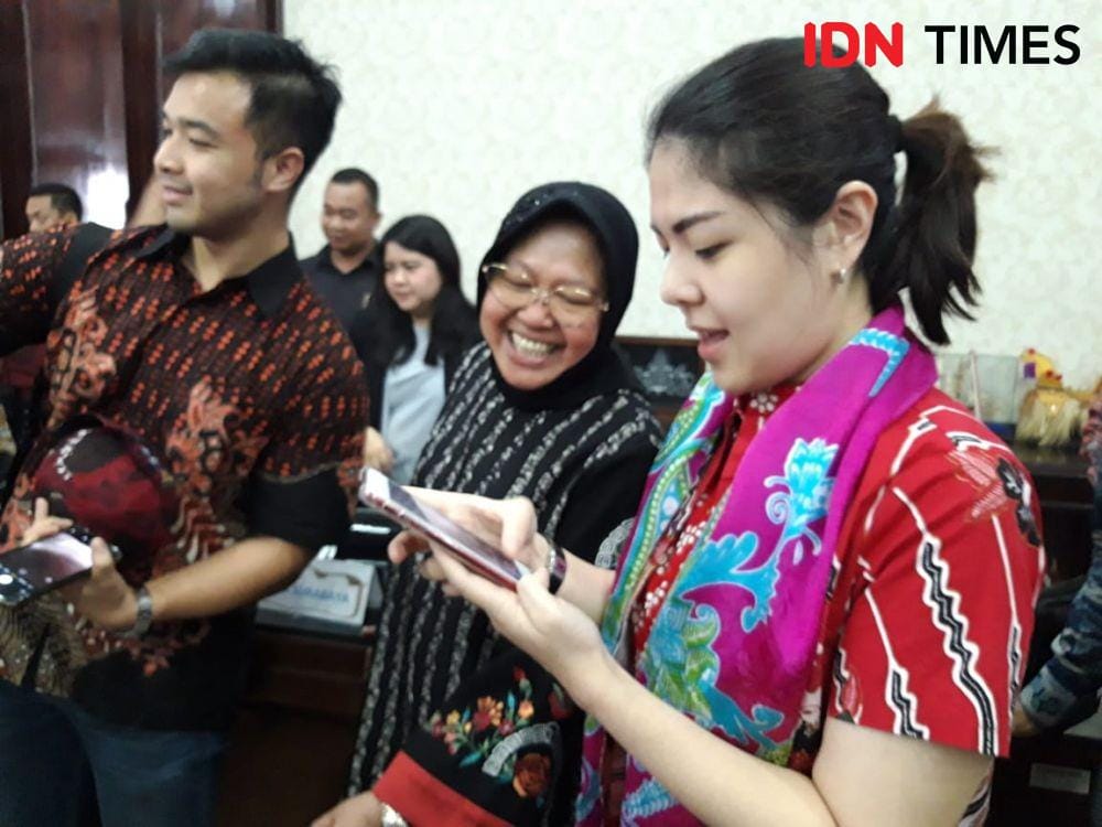 Agustina Hermanto atau Tina Toon (kanan) mengajak Wali Kota Surabaya Tri Rismaharini berswafoto saat kunjungan di Ruang Sidang Wali Kota Surabaya, Jumat (20/12). IDN Times/Fitria Madia
