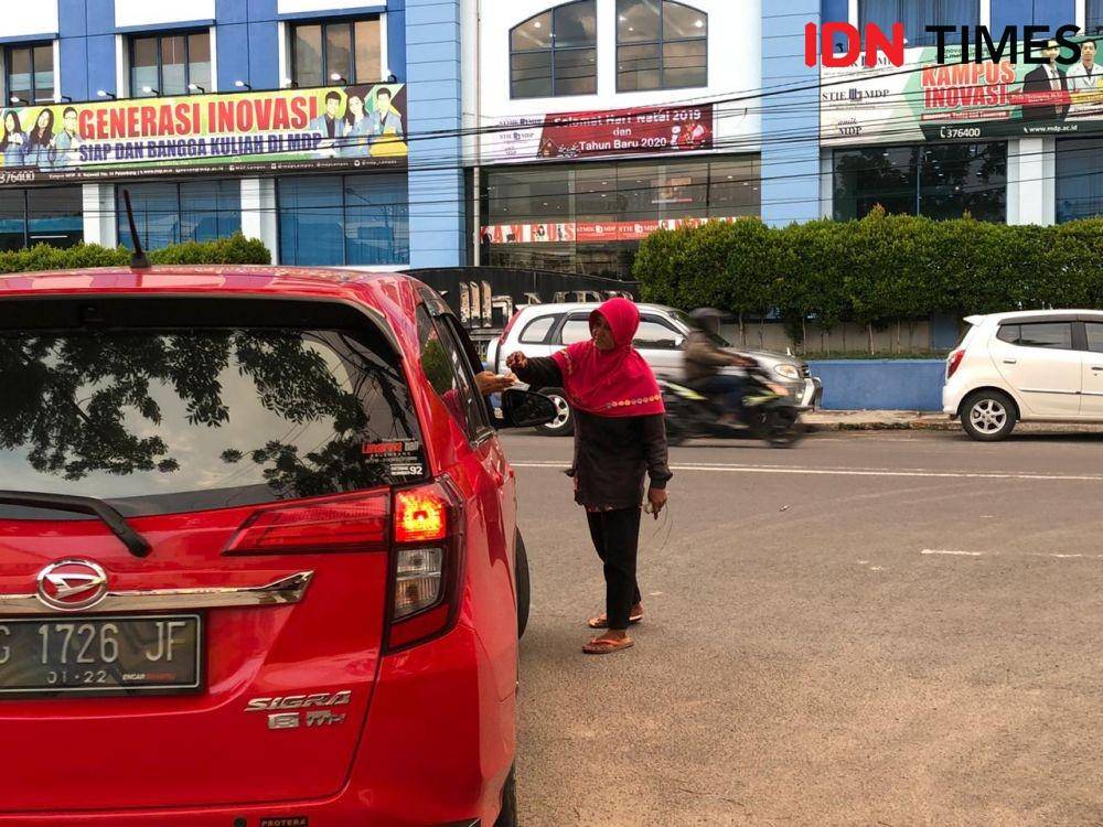 Nani mengatur mobil yang keluar masuk (IDN Times/Rangga Erfizal)