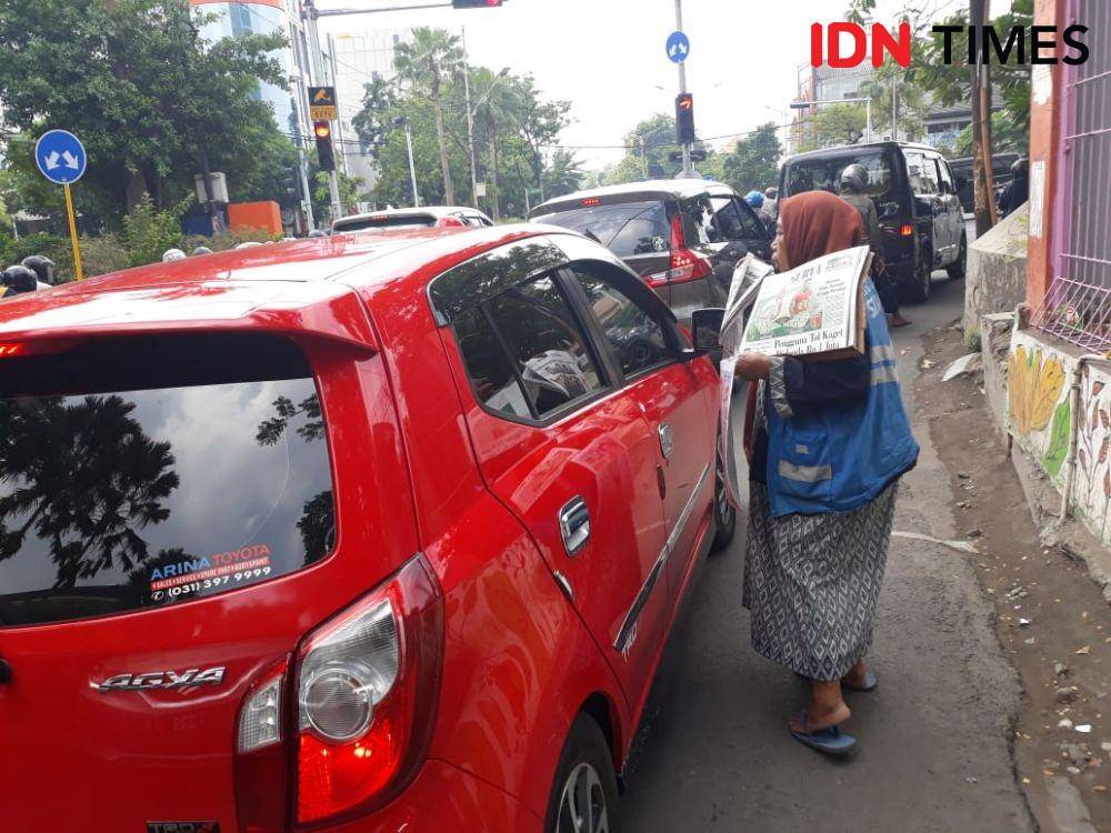 Sri saat berjualan koran di perempatan Jalan Tambang Boyo, Surabaya, samping Fakultas Kedokteran Gigi Universitas Airlangga, pada 21 Desember 2019. IDN Times/Edwin Fajerial