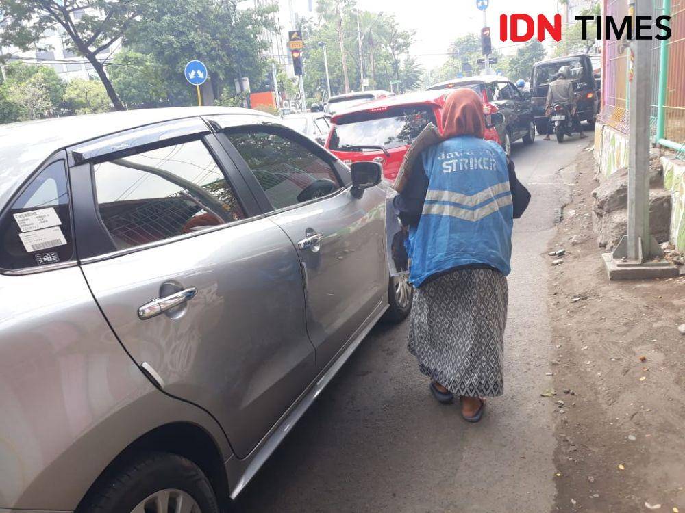 Sri saat berjualan koran di perempatan Jalan Tambang Boyo, Surabaya, samping Fakultas Kedokteran Gigi Universitas Airlangga, pada 21 Desember 2019. IDN Times/Edwin Fajerial