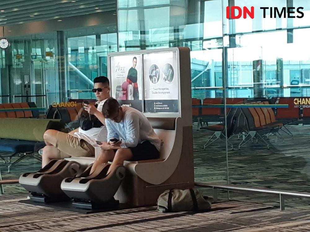 Dua orang penumpang di Changi Airport tampak menikmati fasilitas pijat kaki gratis. IDN Times/Ardiansyah Fajar