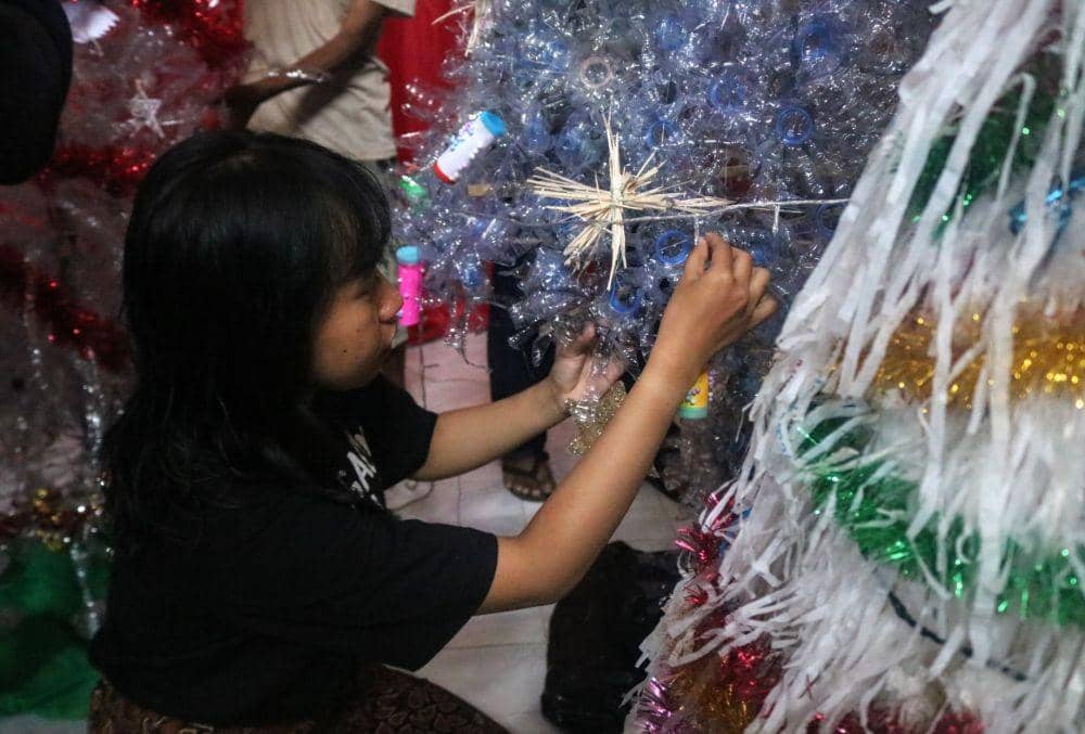Jemaat saat menghias pohon Natal yang terbuat dari bahan daur ulang. IDN Times/ Alfi Ramadana
