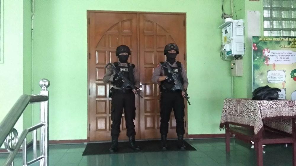 Dua petugas kepolisian Polres Tuban tengah berjaga di pintu masuk gereja. IDN Times/Imron
