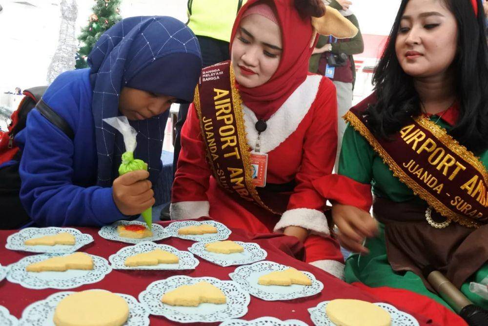 Penumpang di Bandara Juanda diajak Duta Bandara menghias kue Natal, Rabu (25/12). Dok.IDN Times/Istimewa