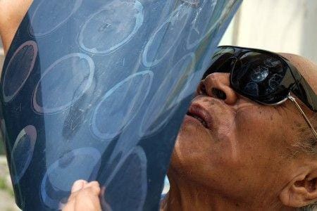 Warga melihat fenomena gerhana matahari sebagian menggunakan film rontgen, di Medan, Sumatera Utara, Kamis (26/12/2019). Fenomena gerhana matahari cincin dan sebagian dapat dilihat di sejumlah wilayah di Indonesia, di antaranya, Sumatera Utara, Riau dan Kalimantan Barat. ANTARA FOTO/Irsan Muyadi