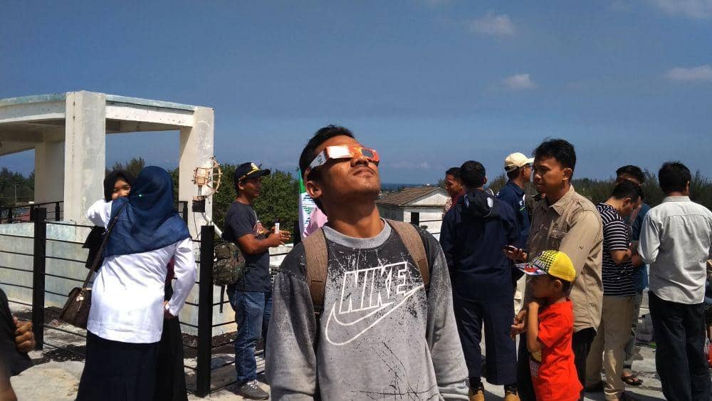 Salah seorang warga ketika melihat gerhana menggunakan kacamata filter. IDN Times/Saifullah