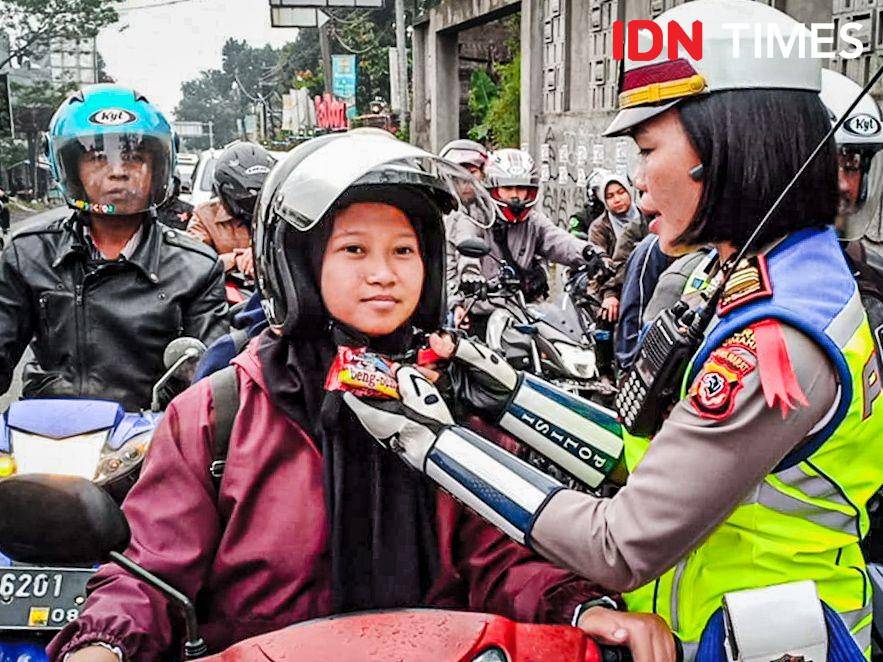 Petugas polisi bagi-bagi jajanan gratis saat atur macet di jalur wisata Lembang. (IDN Times/Bagus F)