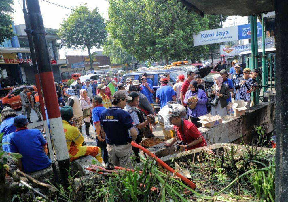 Warga dari berbagai unsur bergotong royong melakukan pembersihan area selokan hingga bawah jembatan. Dok/ Humas Pemkot Malang