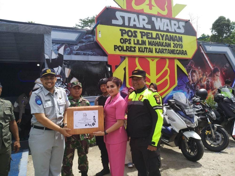 Ketua Bhayangkari Polres Kukar Maria Andreas Susanto Nugroho menyerahkan bingkinsan untuk petugas Pos Lilin Mahakam 2019 (Dok.IDN Times/Istimewa)