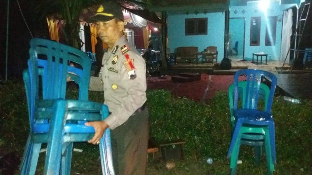 Anggota Polsek Puring membereskan kursi yang porak-poranda setelah angin kencang menerjang resepsi pernikahan keluarga Amrih (44), warga Desa Bumireja, Kecamatan Puring, Kebumen, Sabtu (28/12). Humas Pemkab Kebumen