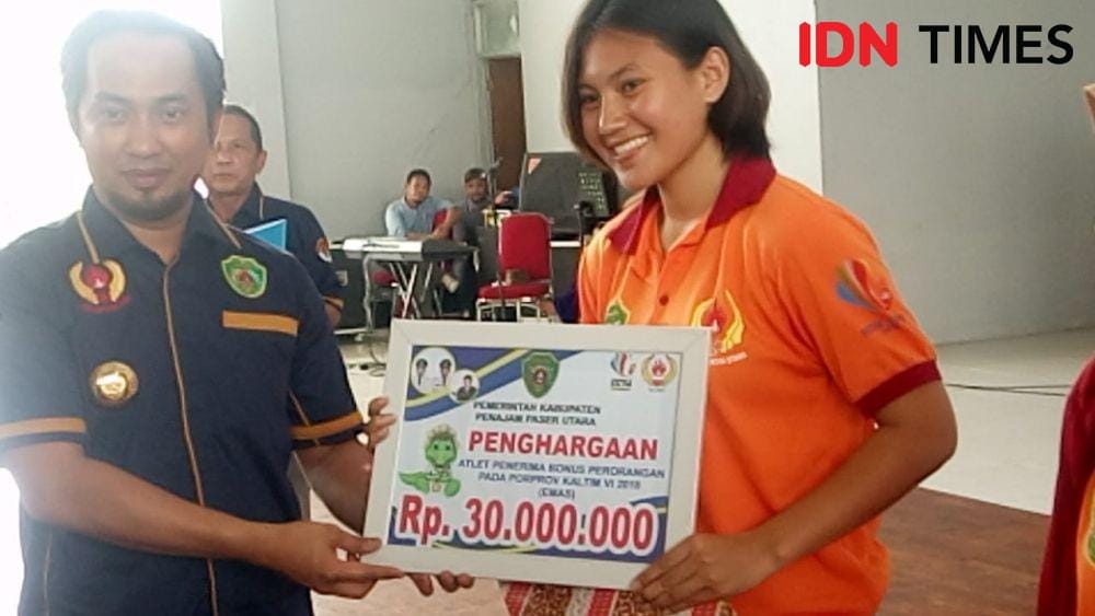Bupati PPU, Abdul Gafur Mas'ud menyerahkan secara simbolis bonus peraih mendali emas kepada atlet Muay Thai PPU Julia Rizki Alfidayanti Sukma Adibowo (IDN Times/Ervan Masbanjar)