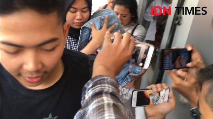Medina Zein digiring ke Puslabfor sambil menutupi wajahnya (IDN Times/Axel Jo Harianja)