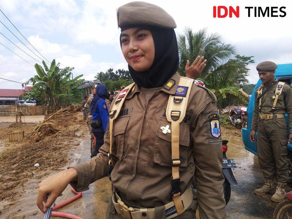 (Aprilia (19), salah satu personel Satpol PP Lebak yang membantu pembersihan jalan berlumpur akibat banjir bandang) IDN Times/khaerul anwar