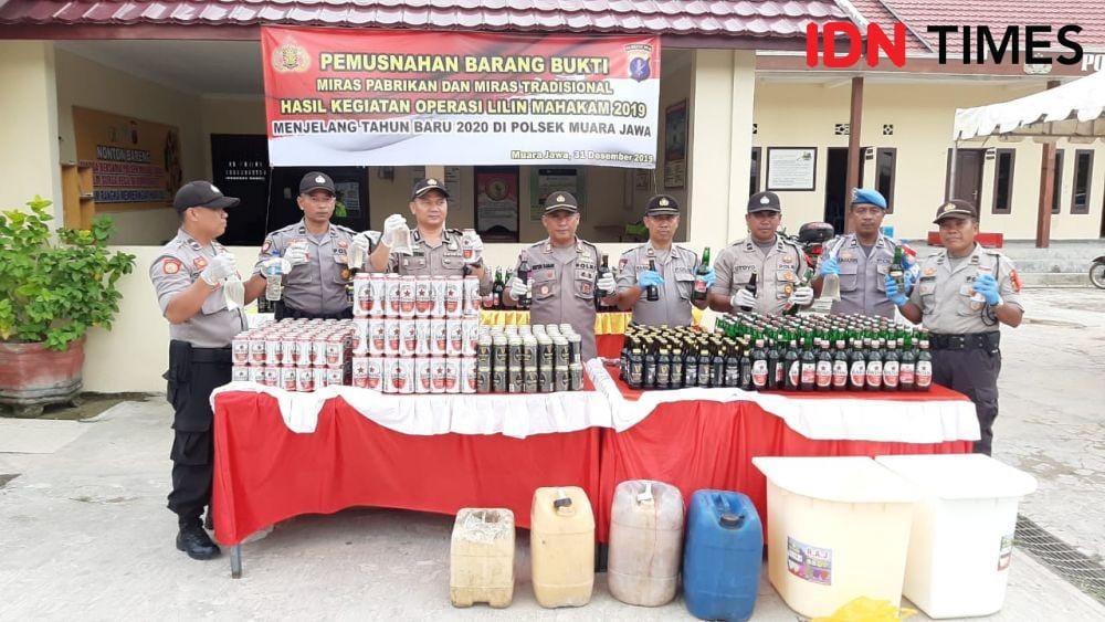 Jajaran Polsek Muara Jawa memperlihatkan miras yang disita jelang tahun baru. (IDN Times/Surya Aditya)