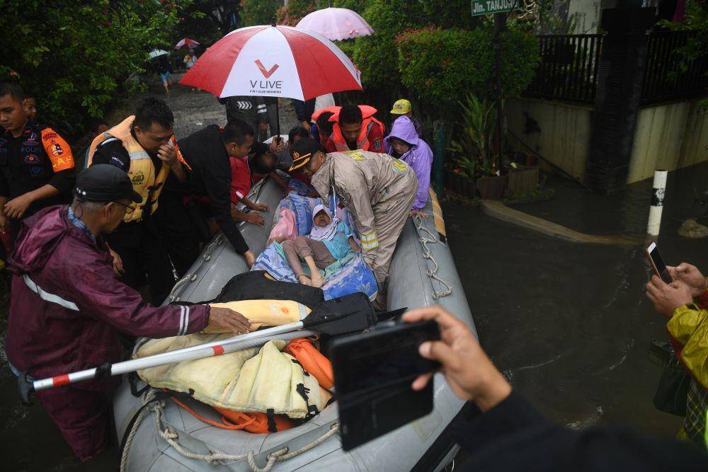 Petugas mengevakuasi warga yang sakit menggunakan perahu karet saat terjadi banjir di Perumahan Bukit Cengkeh 2, Depok, Jawa Barat. ANTARA FOTO/Akbar Nugroho Gumay
