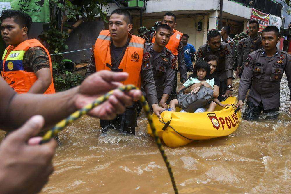 Personel kepolisian dan TNI mengevakuasi warga yang terjebak banjir di kawasan Cipinang Melayu, Jakarta. ANTARA FOTO/Galih Pradipta