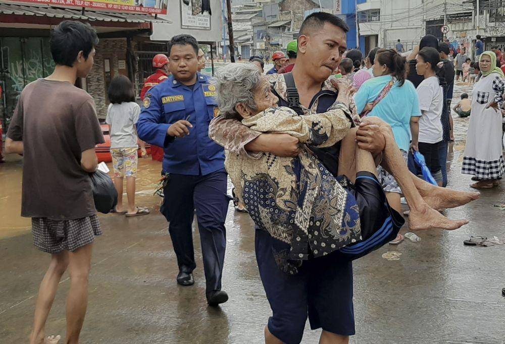 Petugas menggendong salah seorang warga korban banjir di Jalan Jatinegara Barat, Kampung Pulo, Jakarta. ANTARA FOTO/Nova Wahyudi