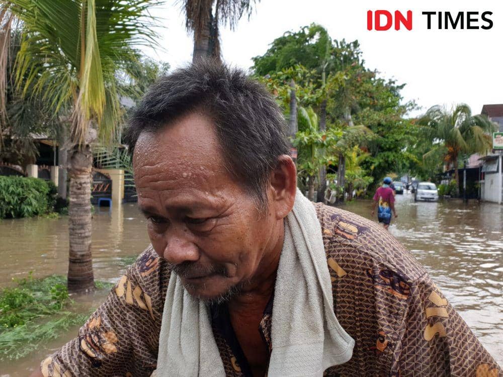 Adang, tukang becak yang mengantarkan warga melewati banjir di Jalan Nangka Raya, Kota Bekasi (IDN Times/Vanny El Rahman)