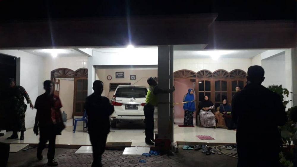 Sejumlah petugas kepolisian memasang garis polisi di sekitar rumah korban. IDN Times/Imron