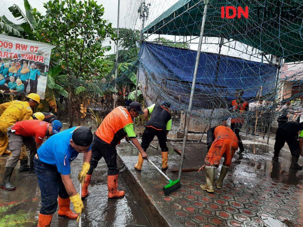 Warga bersama petugas di Jakarta Timur membersihkan lumpur usai banjir melanda pada Rabu (1/1). (IDN Times/Gregorius Aryodamar P)