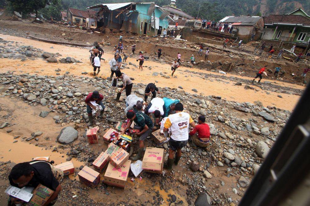 Sejumlah warga mengambil bantuan logistik yang dijatuhkan melalui helikopter di Kampung Muhara, Lebak Gedong, Lebak, Banten. (ANTARA FOTO/Weli Ayu Rejeki)