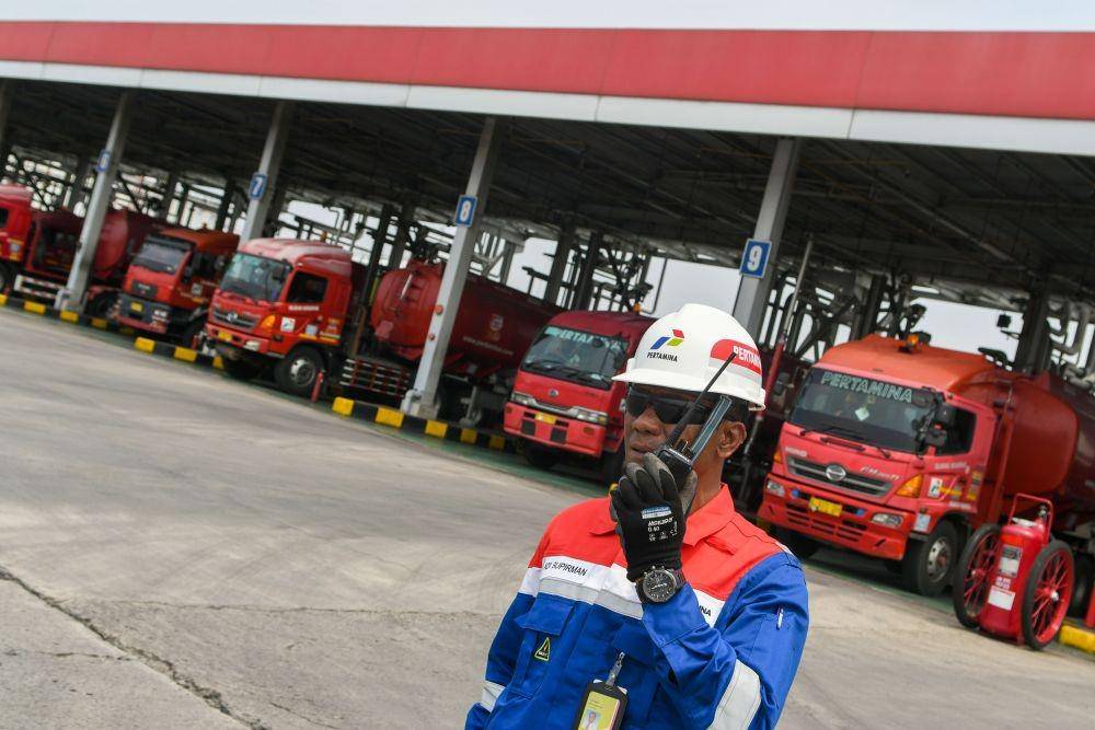 Seorang petugas berada di depan mobil tangki yang melakukan pengisian BBM ke mobil tangki di area pengisian otomatis (New Gantry System) Integrated Terminal BBM Jakarta. ANTARA FOTO/M Risyal Hidayat