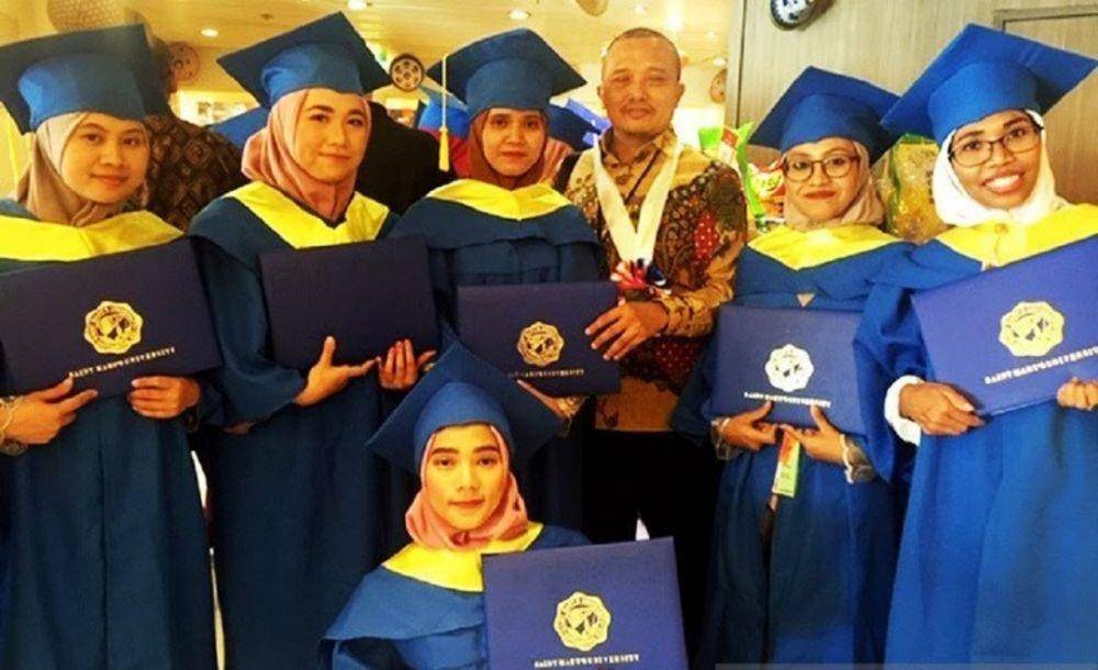 Atase Pendidikan KBRI Beijing Yaya Sutarya (tiga kanan) foto bersama para TKI di Hong Kong yang baru diwisuda di atas kapal pesiar Star Pisces, Minggu (22/9). (ANTARA/HO-KBRI Beijing)
