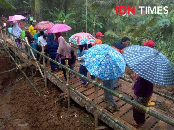 Warga Desa Ponjen, Kecamatan Karanganyar, Purbalingga melintasi jalan darurat yang baru selesai dibangun setelah longsor pada Minggu (5/1).. IDN Times/Rudal Afgani