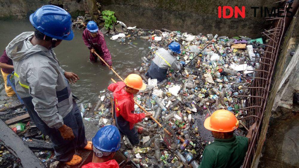 Sejumlah petugas terlihat membersihkan pintu air Tamalabba, Senin (6/1). IDN Times/Asrhawi Muin